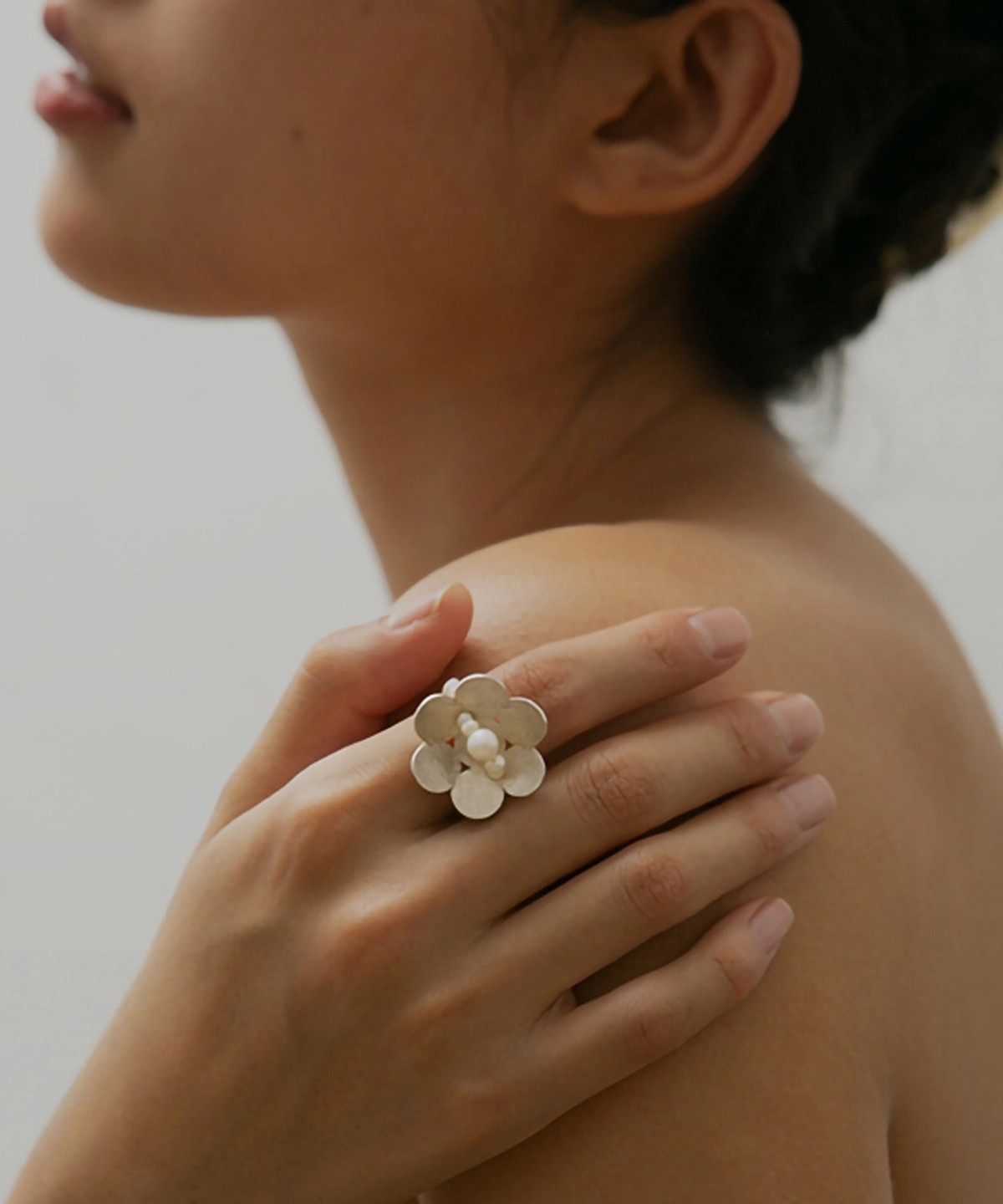 Close-up of a hand wearing the Little Flower Beaded Ring in S925 sterling silver, featuring a delicate floral motif with natural freshwater pearls. Handmade by Lazesoul, this beaded ring captures timeless elegance and organic charm.