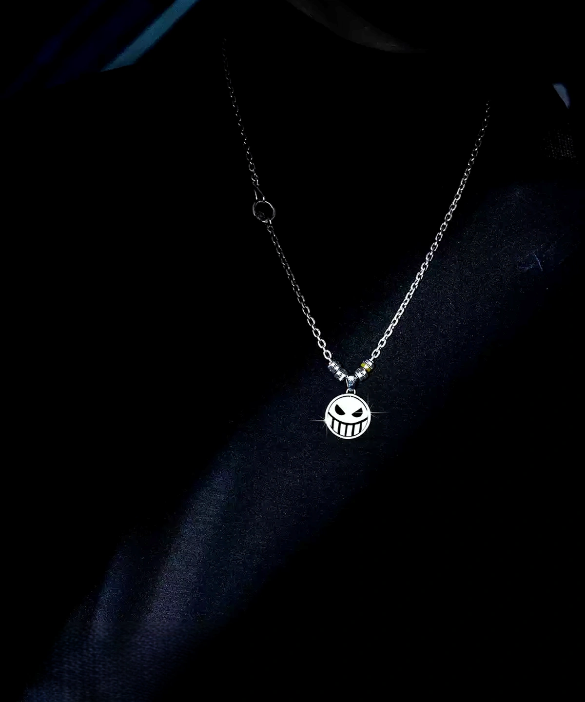 A handcrafted S925 silver pirate necklace with a reversible laugh and cry face spinner pendant inspired by anime. The detailed pendant swings freely on a sleek chain, highlighting One Piece aesthetics and artisan design. Perfect gift for anime fans.