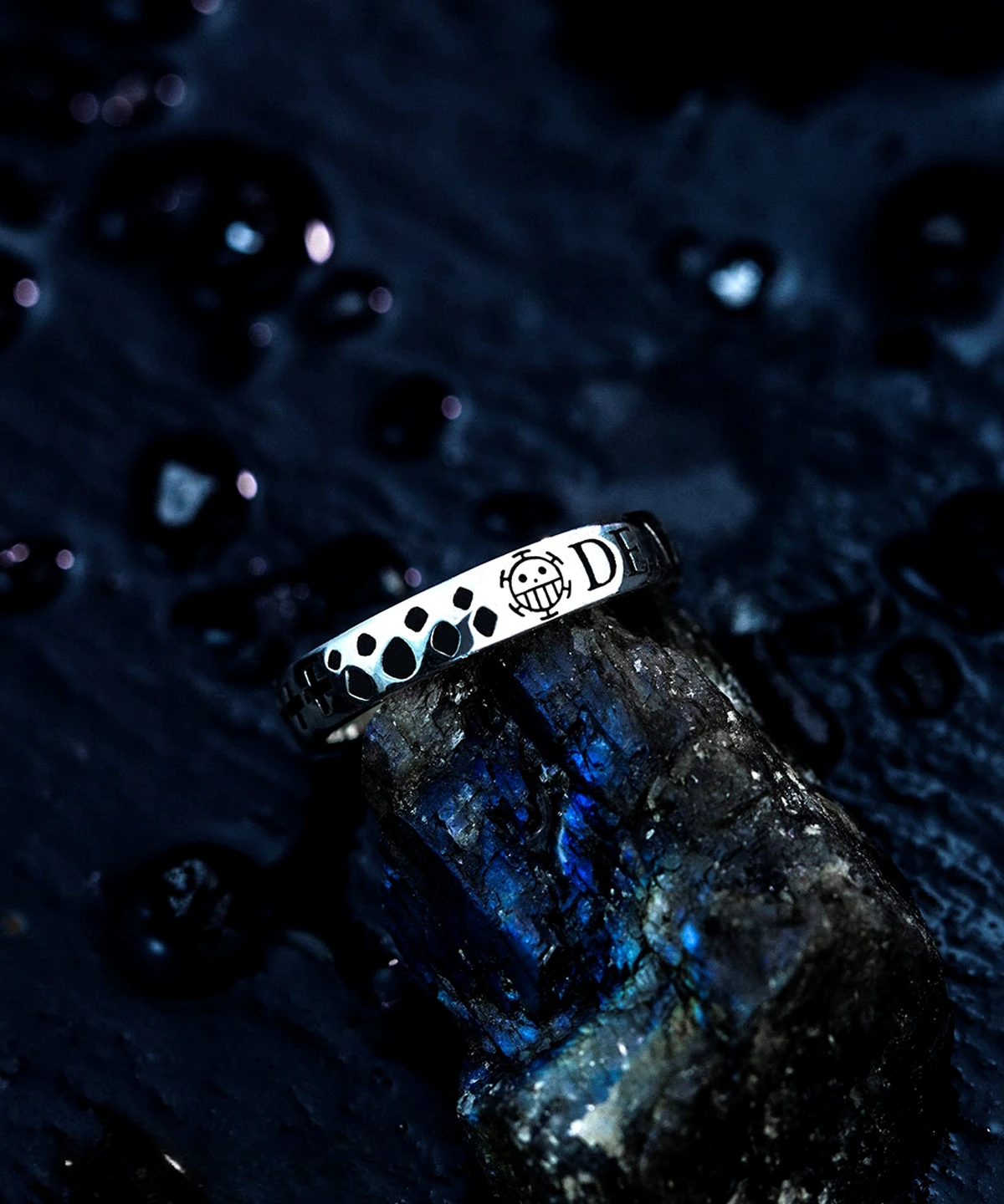 Close-up of a Lazesoul handmade S925 sterling silver pirates ring with a bold skull emblem and engraved word “DEATH,” resting on a moody, water-speckled background. A detailed One Piece-inspired accessory for anime fans. Keywords: Pirates Ring