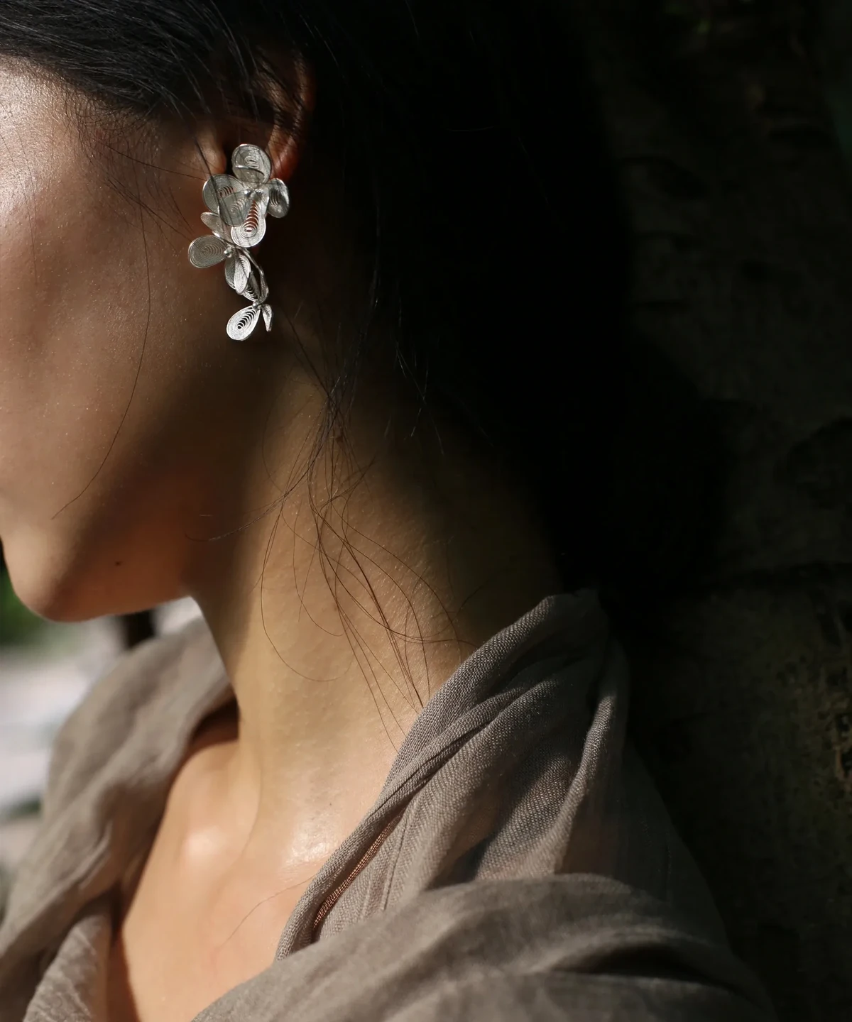 Close-up of a woman wearing Lazesoul Handmade Natural Jewelry's Sterling Silver Filigree Blossom Earrings, featuring intricate floral filigree in S925 silver with a graceful ear cuff and drop earring combination.
