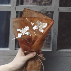 A delicate Iris Bouquet wrapped in rustic brown paper with twine, styled as part of Lazesoul Handmade Art Gifts. Inspired by 925 sterling silver jewelry design, this mini bouquet highlights artisanal charm and timeless elegance for unique art gifts.