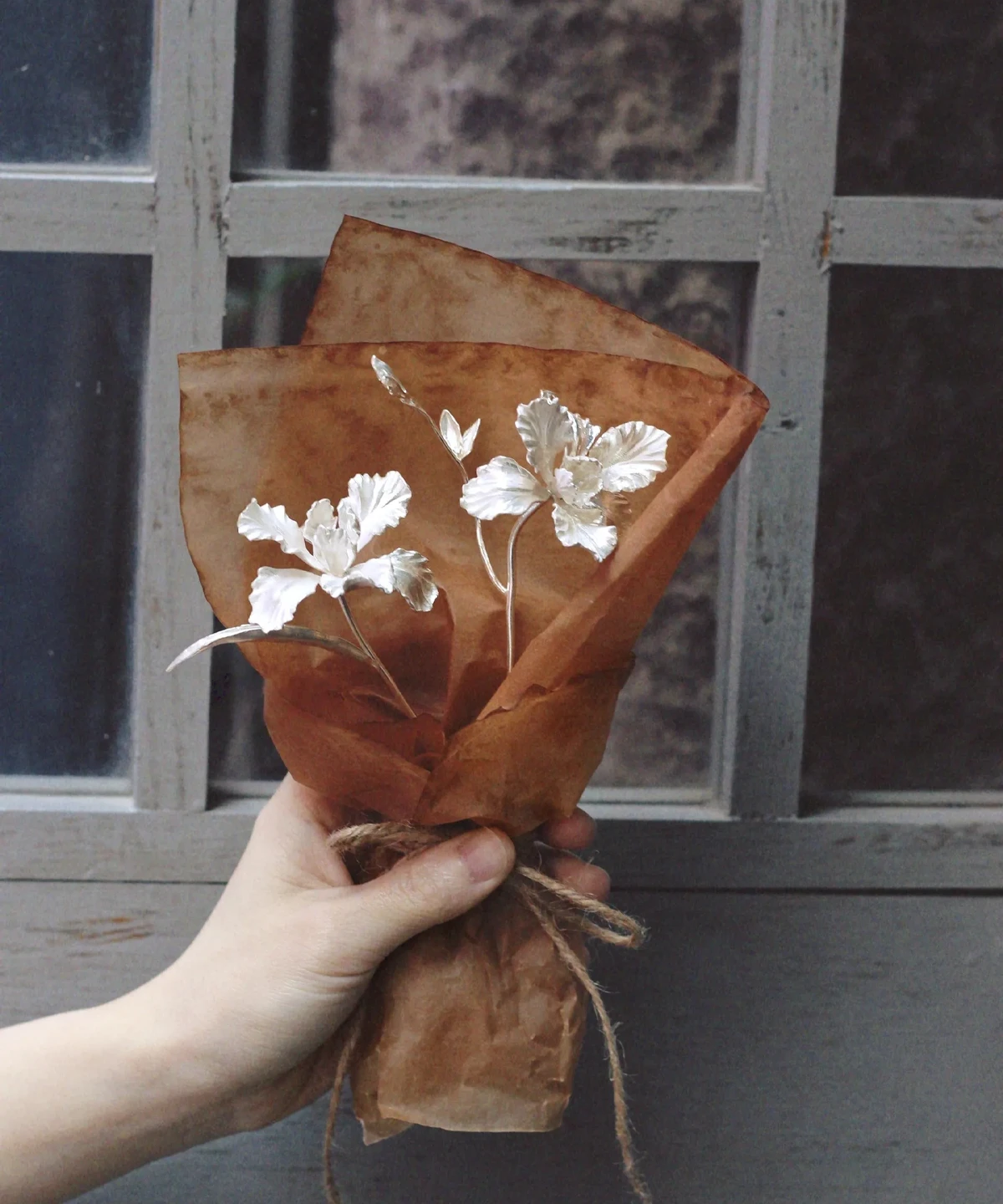 A delicate Iris Bouquet wrapped in rustic brown paper with twine, styled as part of Lazesoul Handmade Art Gifts. Inspired by 925 sterling silver jewelry design, this mini bouquet highlights artisanal charm and timeless elegance for unique art gifts.