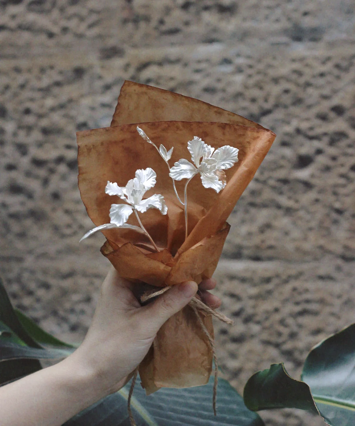 Hand holding a delicate Iris Bouquet wrapped in parchment paper, symbolizing Lazesoul Handmade Art Gifts. Features 925 sterling silver design, perfect as timeless Art Gifts with nature-inspired elegance.
