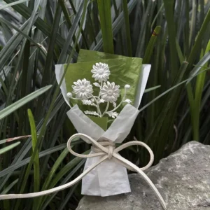 Handmade 925 sterling silver mini daisy bouquet displayed on a rock with green grass background. Elegant white petals and lifelike details make this Daisy Bouquet a perfect choice for nature-inspired art gifts and timeless keepsakes.