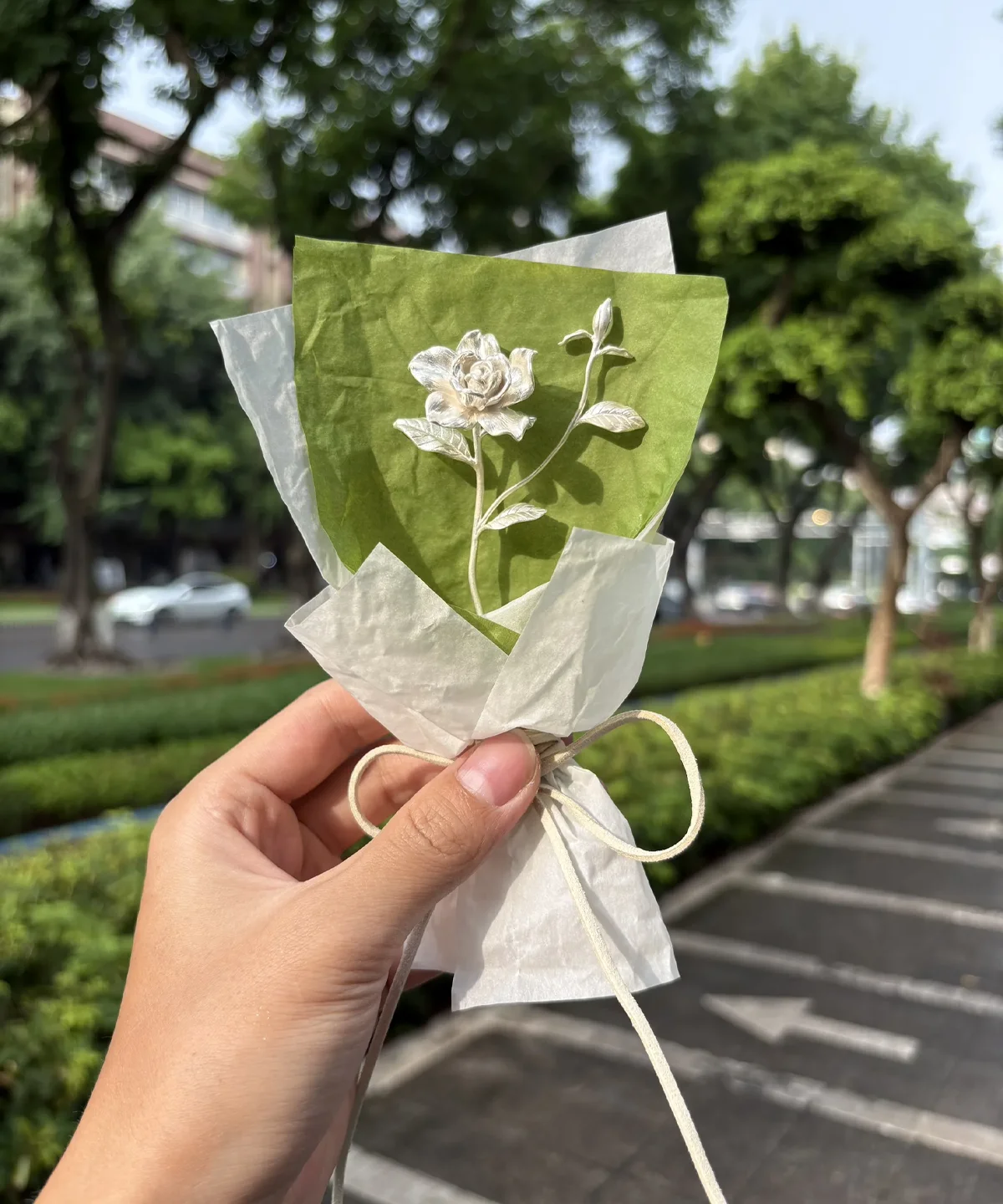 A delicate 925 sterling silver mini gardenia bouquet, handcrafted by Lazesoul. Wrapped in green and white paper with a white ribbon, this elegant design blends artisanal charm and fine detail—perfect for unique art gifts and timeless keepsakes.