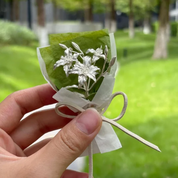 925 Sterling Silver Mini Lily Bouquet-Handmade Art Gifts 06 Handcrafted 925 sterling silver mini lily bouquet wrapped in green and white paper with a white ribbon bow, Lazesoul handmade art gifts. Elegant metallic flowers perfect as unique Lily Bouquet art gifts for special occasions.