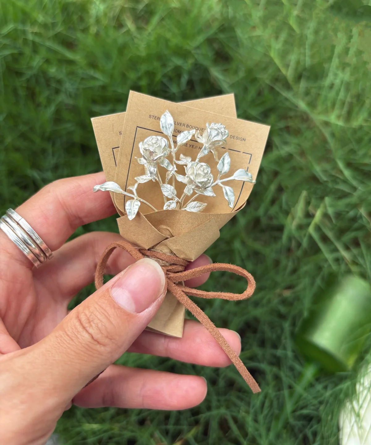 Handcrafted 925 sterling silver mini rose bouquet wrapped in rustic brown paper, tied with twine. A unique handmade art gift by Lazesoul, perfect for romantic keepsakes, anniversaries, or elegant home décor. Keywords: Rose Bouquet, Art Gifts.