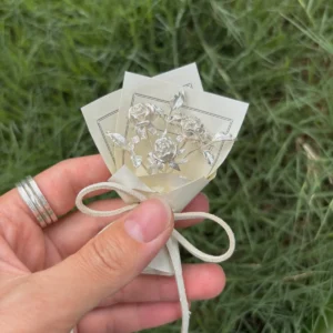 Handcrafted 925 sterling silver mini rose bouquet with delicate metal roses and leaves, tied with a white bow on a cream card. Perfect as unique handmade art gifts, ideal for collectors and lovers of elegant rose bouquet designs.