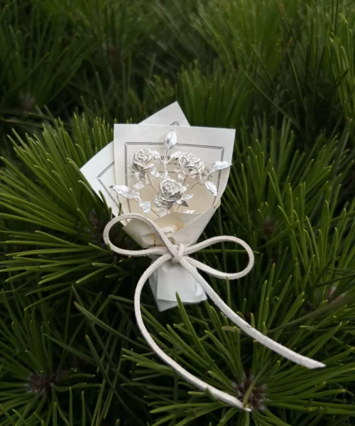 Elegant 925 sterling silver mini rose bouquet on a white card with bow, set against pine needles. Handmade art gift by Lazesoul, perfect for collectors and nature lovers seeking unique rose bouquet jewelry and timeless art gifts.