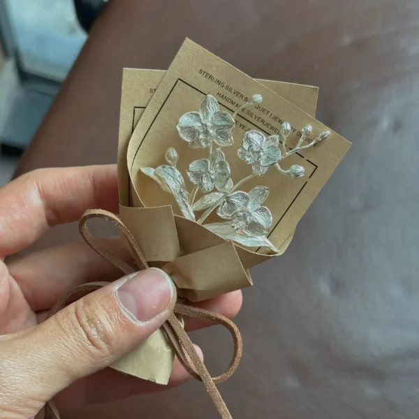Handcrafted 925 sterling silver Phalaenopsis mini bouquet by Lazesoul, wrapped in rustic paper with delicate floral art cards. Elegant handmade art gift perfect for nature lovers, weddings, and unique jewelry-inspired art gifts.