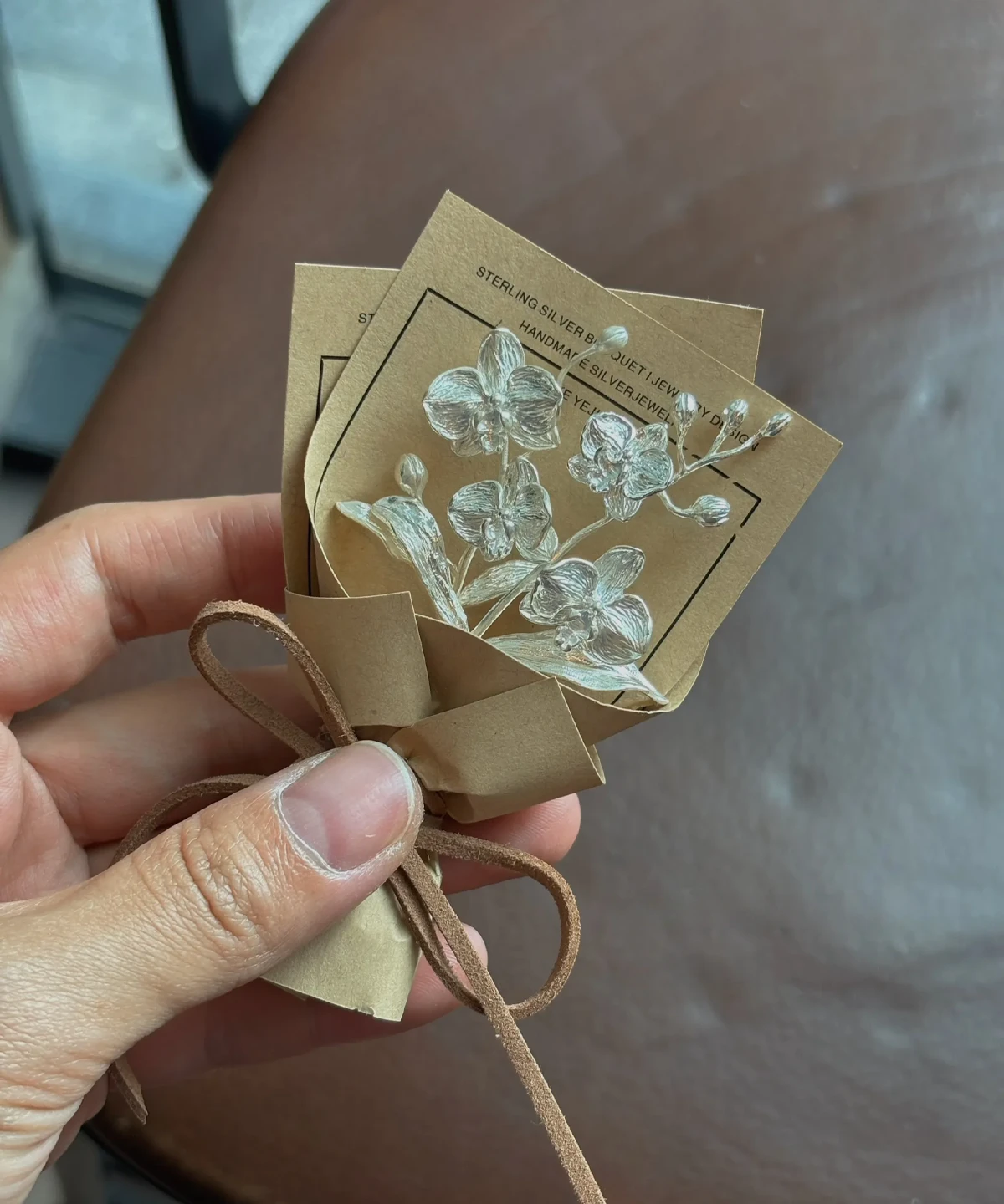 Handcrafted 925 sterling silver Phalaenopsis mini bouquet by Lazesoul, wrapped in rustic paper with delicate floral art cards. Elegant handmade art gift perfect for nature lovers, weddings, and unique jewelry-inspired art gifts.