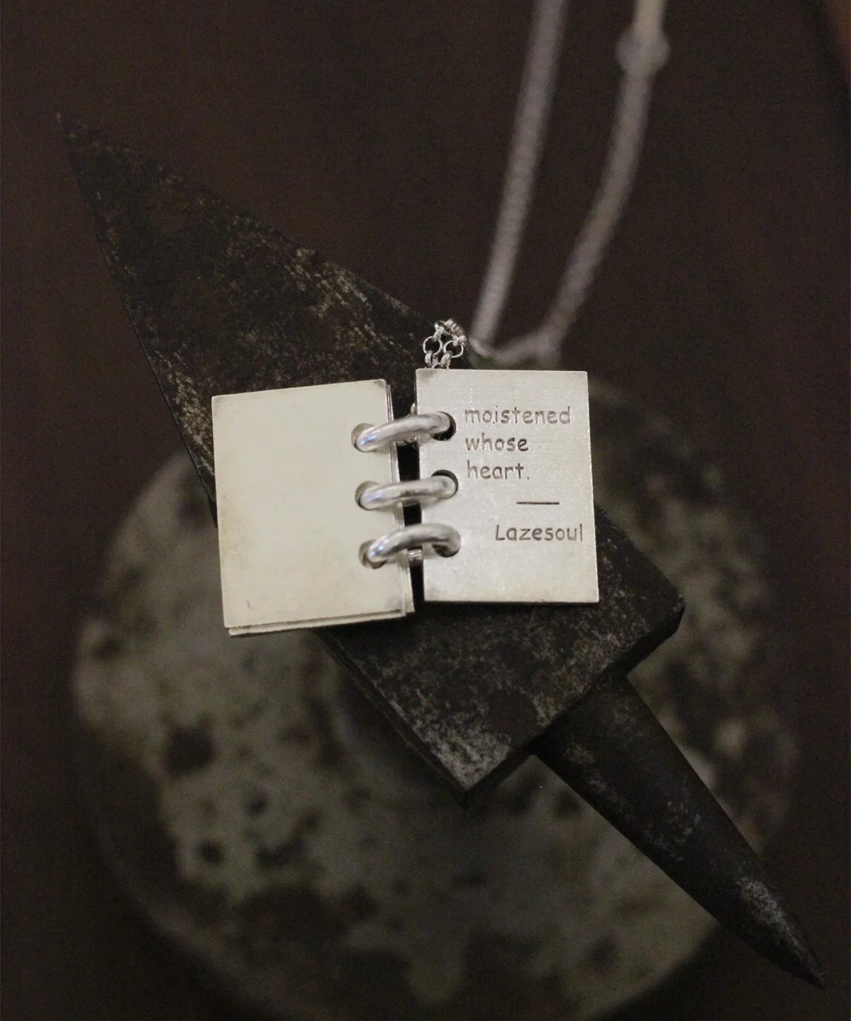 Close-up of Lazesoul Love Letter 925 sterling silver personalized book necklace, handmade with open notebook pendant engraved “moistened whose heart. Lazesoul,” on silver chain. Elegant custom jewelry gift for her.