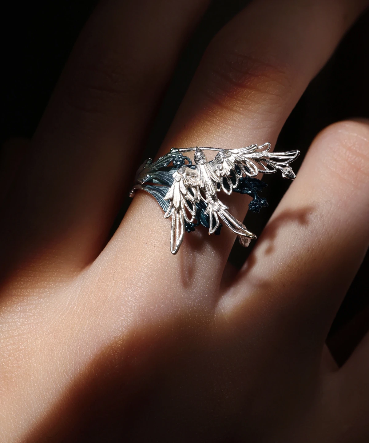 Close-up of Lazesoul handmade jewelry: Stray Birds 925 sterling silver open adjustable statement ring. Intricate feathered wing design with dark band, nature-inspired craftsmanship, elegant bold statement ring for women and men.