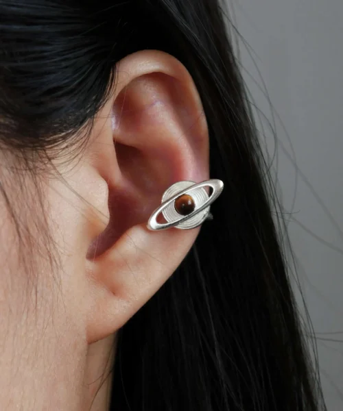 Close-up of ear wearing Lazesoul handmade Saturn Earrings in 925 sterling silver, featuring a polished tiger’s eye gemstone as Saturn with orbit-inspired bands; celestial artisan earrings blending cosmic elegance, astronomy symbolism, and timeless craftsmanship.