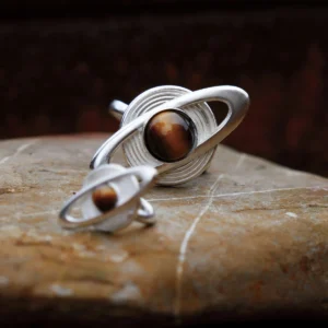 Two Lazesoul handmade jewelry pieces — a Saturn Ring and Saturn Ear Cuff in 925 sterling silver with tiger’s eye gemstones, designed with orbit-inspired bands that echo Saturn’s rings; artisanal celestial jewelry blending cosmic elegance and craftsmanship.