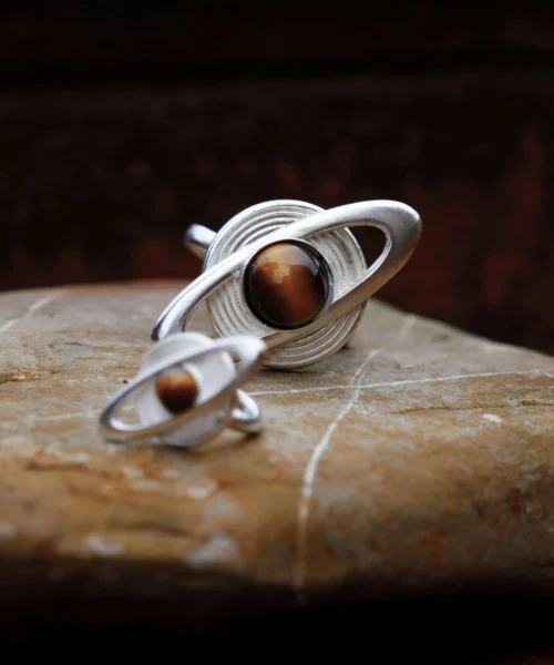 Two Lazesoul handmade jewelry pieces — a Saturn Ring and Saturn Ear Cuff in 925 sterling silver with tiger’s eye gemstones, designed with orbit-inspired bands that echo Saturn’s rings; artisanal celestial jewelry blending cosmic elegance and craftsmanship.
