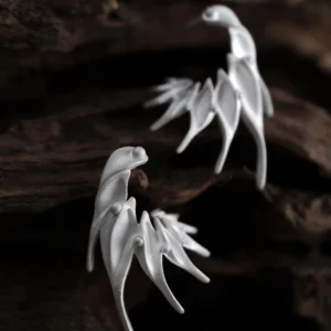 Ethereal Wings S925 Sterling Silver Designer Earrings by Lazesoul. Handmade art jewelry with wing‑like curves and sculptural organic forms. Unique designer earrings crafted with elegance, artistry, and timeless sophistication against dark wood background.