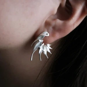 Close‑up of Lazesoul Ethereal Wings S925 Sterling Silver Designer Earrings worn on ear. Handmade art jewelry with flame‑like sculptural curves and elongated silver spikes. Unique designer earrings showcasing bold, modern elegance and craftsmanship.