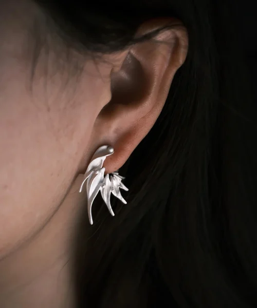 Close‑up of Lazesoul Ethereal Wings S925 Sterling Silver Designer Earrings worn on ear. Handmade art jewelry with flowing, leaf‑like curves and sculptural organic design. Unique designer earrings showcasing elegance, craftsmanship, and timeless style.