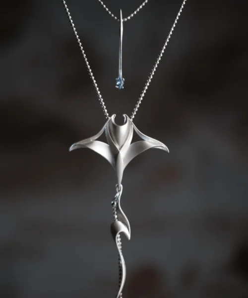 Close-up of Lazesoul Handmade Nature Jewelry S925 Sterling Silver Stacked Manta Ray Necklace, showing a layered manta ray pendant with smooth flowing curves and a sparkling gemstone accent on a delicate silver chain against a dark background.
