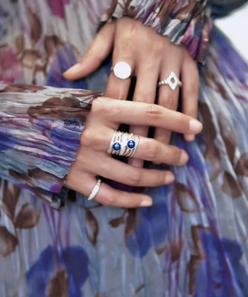 Two hands adorned with multiple Silver Rings, including June Birthstone Rings with natural black pearls; elegant Black Pearl Ring designs paired with floral-patterned sleeves, showcasing layered sterling silver craftsmanship and poetic styling.