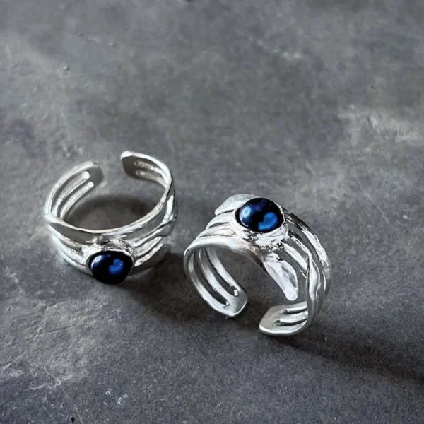 June Birthstone Ring-Natural Black Pearl Ring in Sterling Silver 06 Two sculptural Silver Rings featuring natural black pearls set in open-ended bands; elegant June Birthstone Ring designs with layered metalwork and glossy stones, ideal for showcasing handcrafted Black Pearl Ring artistry.