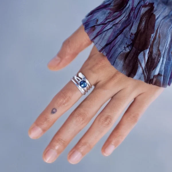June Birthstone Ring-Natural Black Pearl Ring in Sterling Silver 09 Close-up of a hand wearing a June Birthstone Ring with natural black pearl on a split sterling silver band; elegant Black Pearl Ring paired with floral-patterned sleeve and minimalist tattoo, highlighting artisanal Silver Ring craftsmanship.