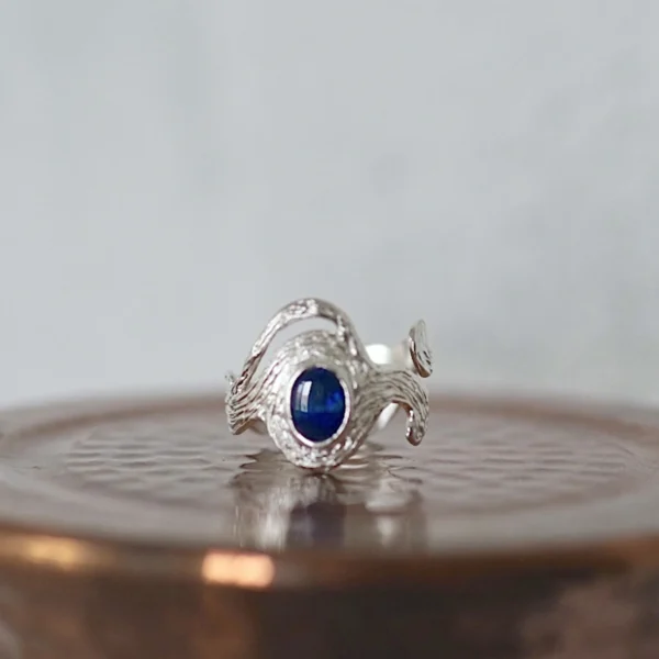 Sterling Silver Ring with deep blue natural black opal set in a sculptural, wave-like band; elegant October Birthstone Ring design showcasing handcrafted Silver Ring artistry and the mysterious glow of the Black Opal Ring.