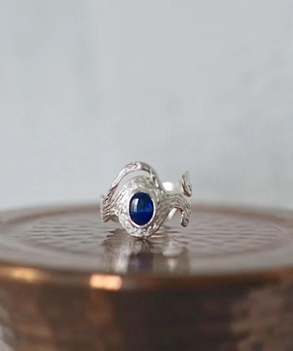 Sterling Silver Ring with deep blue natural black opal set in a sculptural, wave-like band; elegant October Birthstone Ring design showcasing handcrafted Silver Ring artistry and the mysterious glow of the Black Opal Ring.