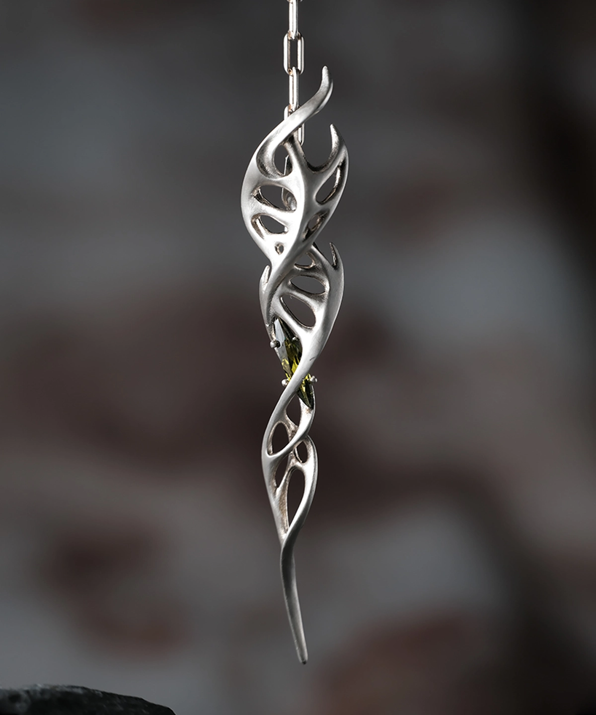 Close-up of Lazesoul Handmade S925 Sterling Silver Spiral Pendant Necklace on chain. The spiral pendant features elongated silver segments with leaf-like cutouts and a green gemstone at the center, highlighting the elegant spiral necklace craftsmanship.