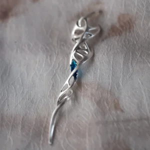 Close-up of Lazesoul Handmade S925 Sterling Silver Spiral Pendant Necklace on fabric background. The spiral pendant features flowing vine-like silver curves with loops and a deep blue gemstone at the center, highlighting the artistry of this elegant spiral necklace.