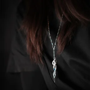 Close-up of Lazesoul Handmade S925 Sterling Silver Spiral Pendant Necklace worn with dark clothing. The spiral pendant features an elongated twisted silver design accented with blue details, standing out against the fabric. Elegant spiral necklace craftsmanship.