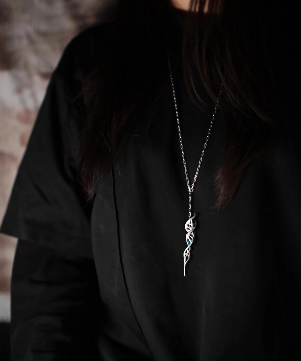 Close-up of Lazesoul Handmade S925 Sterling Silver Spiral Pendant Necklace worn with a black shirt. The spiral pendant features a DNA-inspired double helix silver design, hanging centrally on the chest, highlighting the elegant craftsmanship of this spiral necklace.