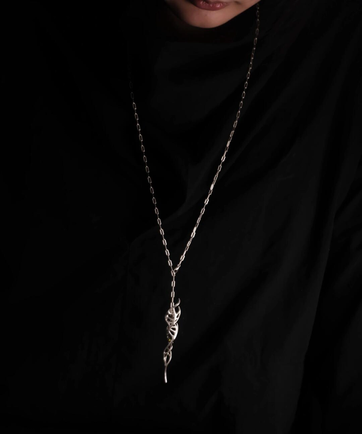 Close-up of Lazesoul Handmade S925 Sterling Silver Spiral Pendant Necklace worn with black clothing. The spiral pendant features a DNA-inspired double helix silver design, hanging centrally on the chest, highlighting the elegant craftsmanship of this spiral necklace.