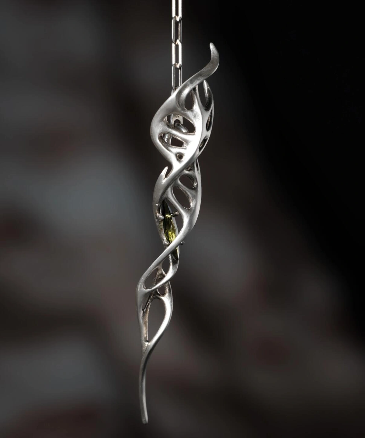 Close-up of Lazesoul Handmade S925 Sterling Silver Spiral Pendant Necklace on textured fabric. The spiral pendant features flowing silver curves with vine-like twists and embedded blue gemstones, highlighting the refined artistry of this elegant spiral necklace.