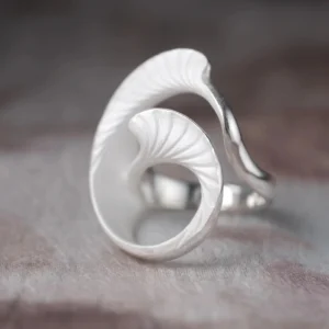 Arc Glow S925 Sterling Silver Ring with sculptural leaf-inspired design, featuring curved, textured elements and matte finish; a nature-inspired Unique Ring styled on hand against organic surface and dark background.