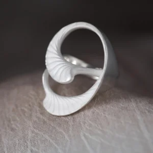 Arc Glow S925 Sterling Silver Ring with sculptural leaf-inspired design and matte vein-textured surface; a nature-inspired Unique Ring featuring intertwined curved forms, styled on a textured neutral background.