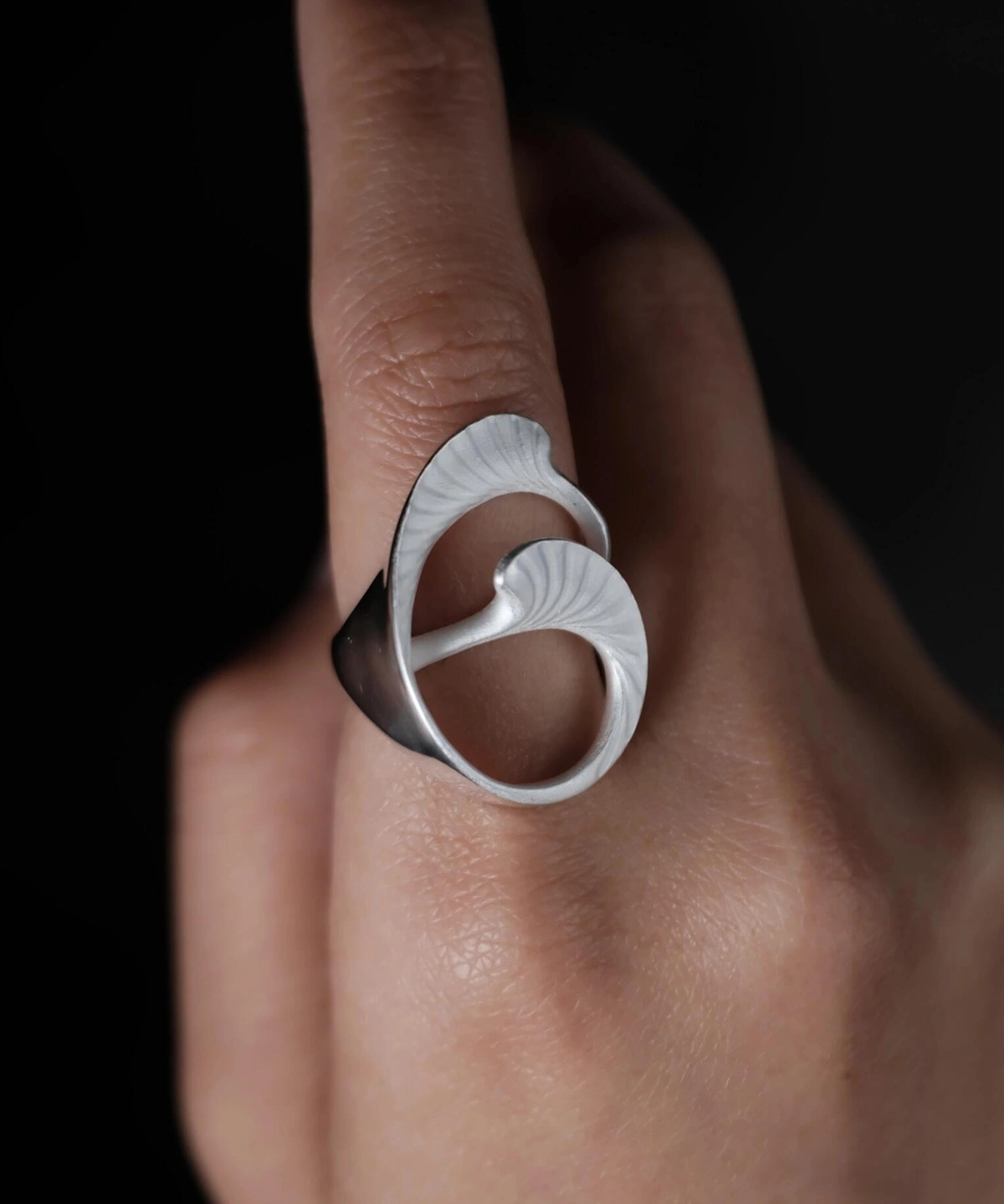 Arc Glow S925 Sterling Silver Ring with sculptural ginkgo leaf-inspired design and polished surface; a nature-inspired Unique Ring featuring curved organic forms and fine textures, worn on hand and styled against a dark background.