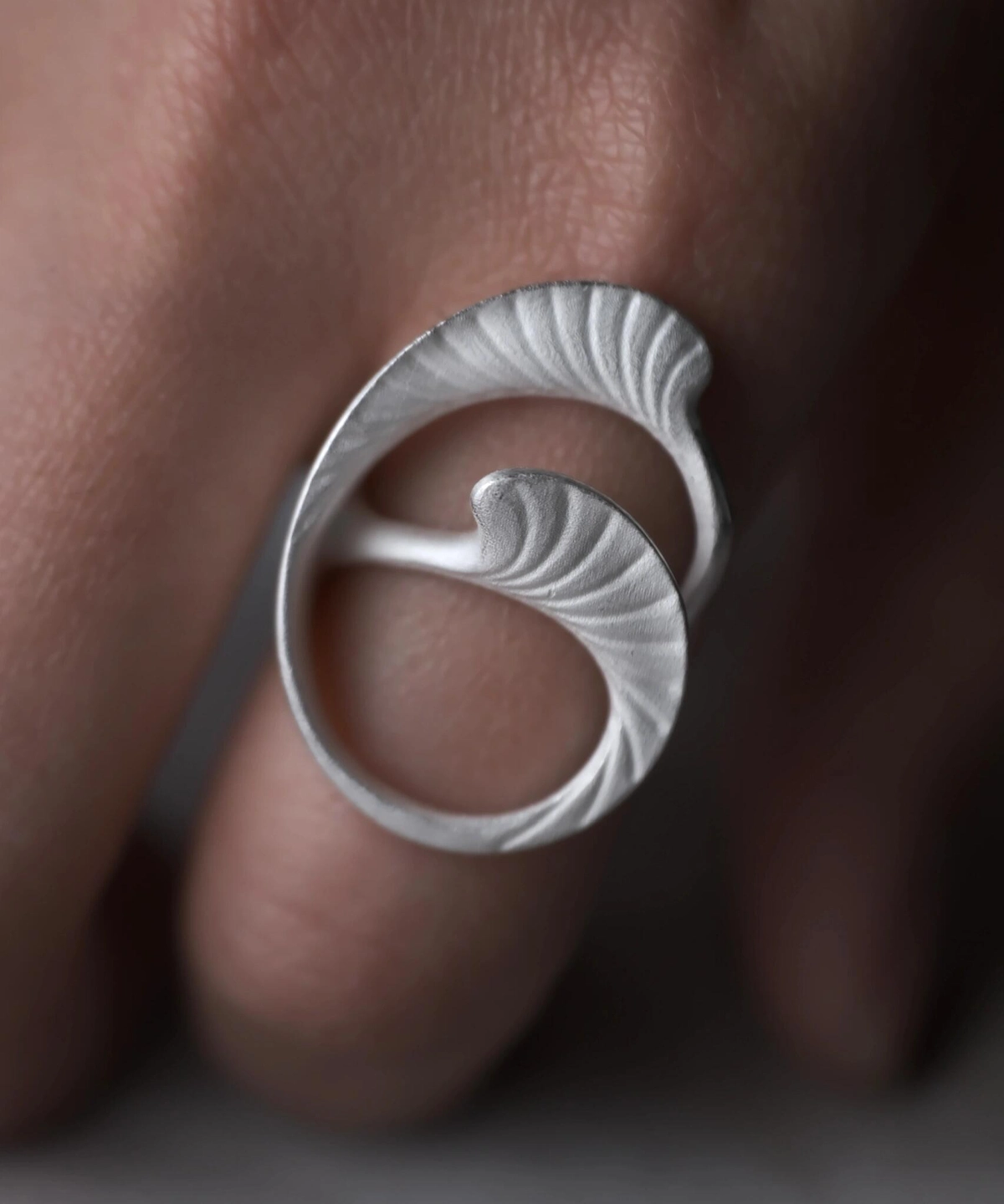 Arc Glow S925 Sterling Silver Ring with sculptural swirling design and textured wave-like surface; a nature-inspired Unique Ring featuring flowing abstract curves, worn on hand and styled against a dark background.