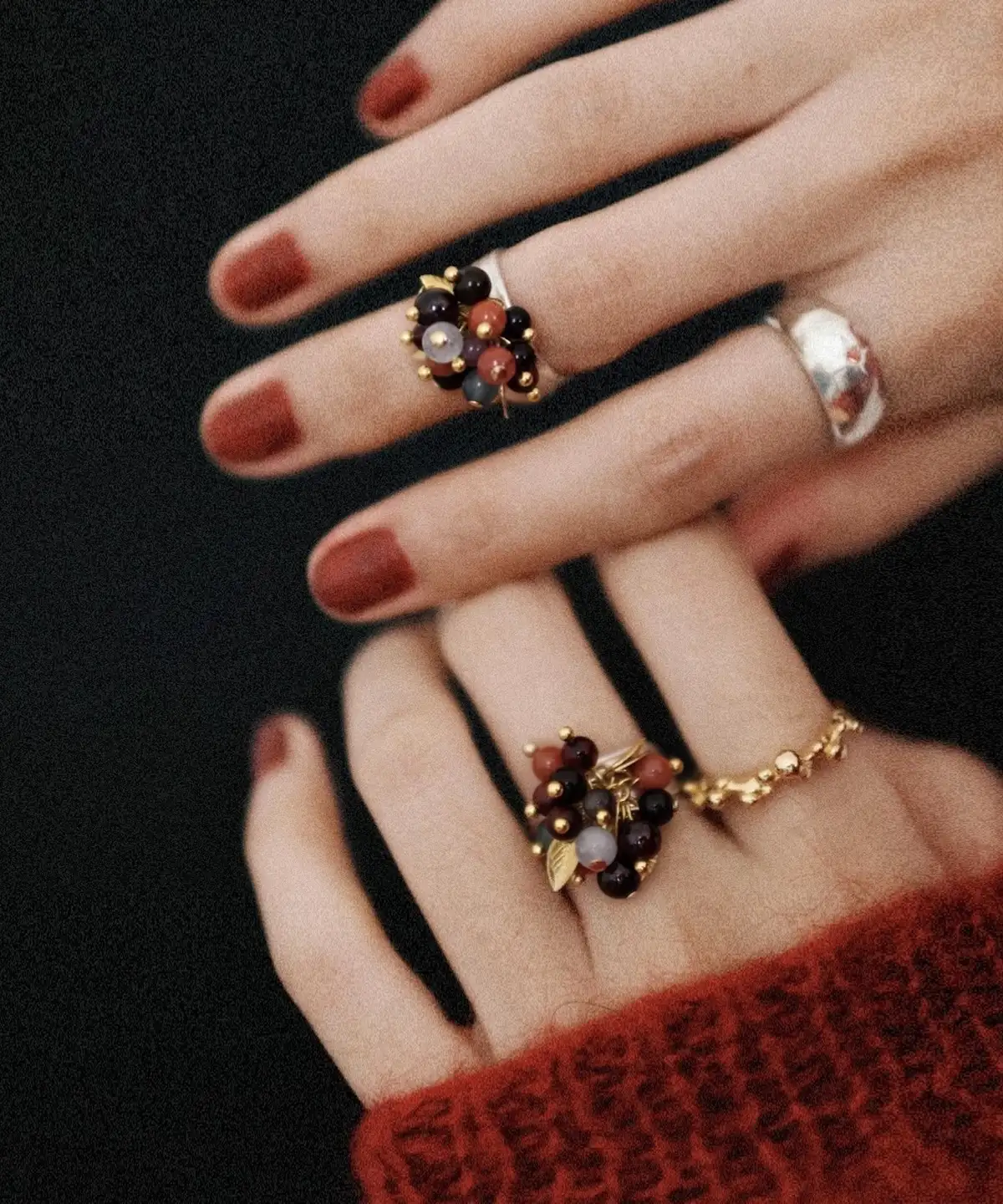 925 Sterling Silver Ring with multicolored Natural Stone beads in black, red, purple, and gold, worn on hands with dark red nails and paired with textured silver and gold bands; a handcrafted Natural Stone Ring with botanical charm.