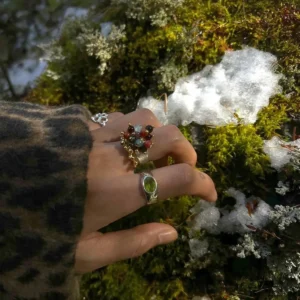 925 Sterling Silver Ring with multicolored Natural Stone beads and golden accents, worn on hand resting on moss and snow; a handcrafted Silver Ring with botanical charm and vibrant detail in a natural outdoor setting.