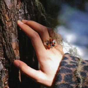 925 Sterling Silver Ring with multicolored Natural Stone beads and golden leaf accents, worn on hand touching tree bark with moss and lichen; a handcrafted Silver Ring blending organic charm and forest-inspired elegance.