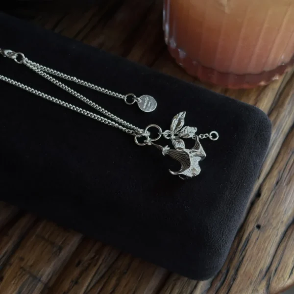 Handmade S925 Silver Necklace featuring a stylized datura flower pendant with antlers and leaves, displayed on black velvet; includes custom disc charm. A unique Silver Necklace with botanical and fantasy-inspired design.