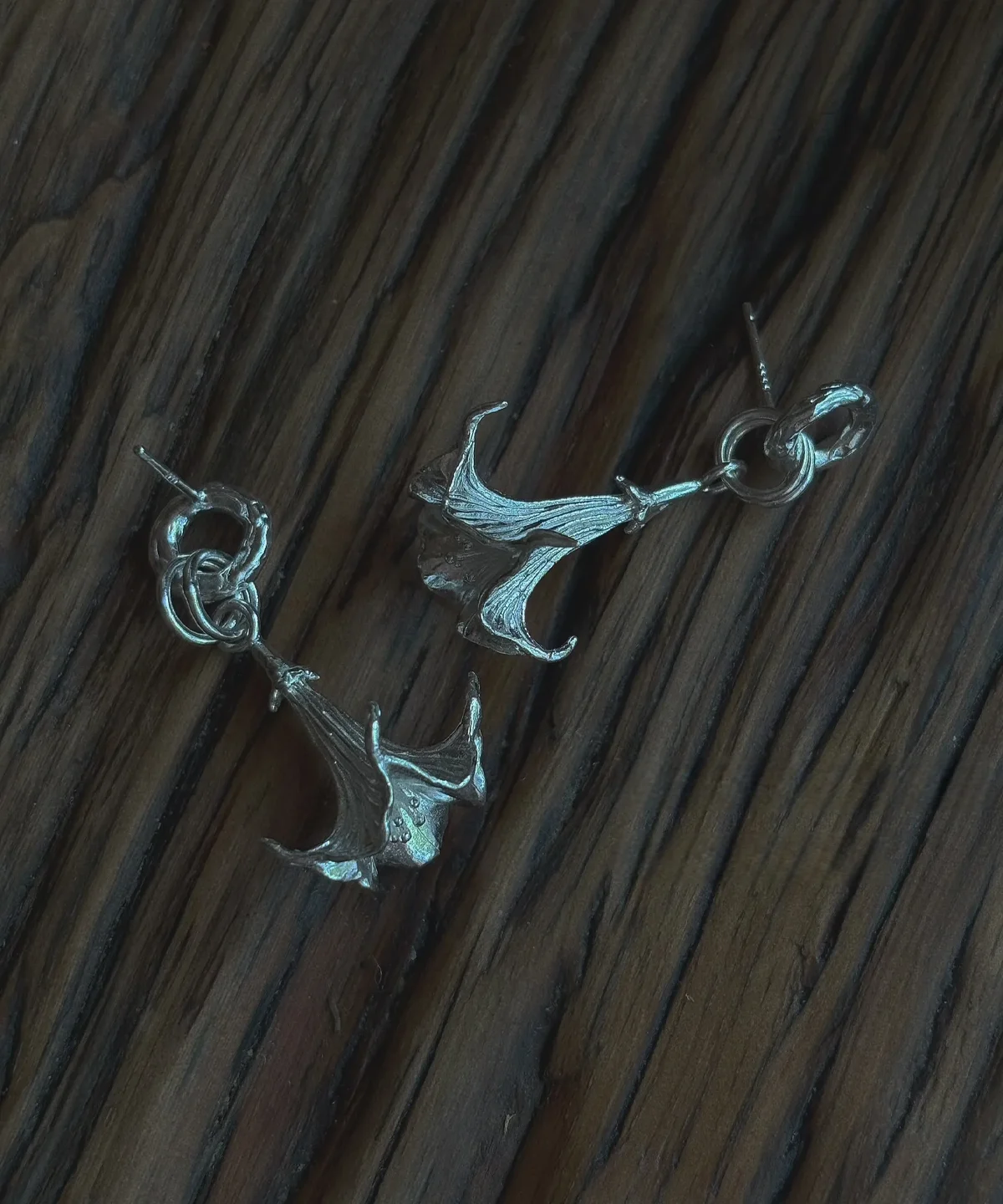 Datura-Handcrafted S925 Sterling Silver Flower Earrings 09 S925 Sterling Silver Datura Flower Earrings with trumpet-shaped bloom and looped stud design; handcrafted Silver Earrings styled on wood surface, showcasing botanical elegance and intricate metalwork.