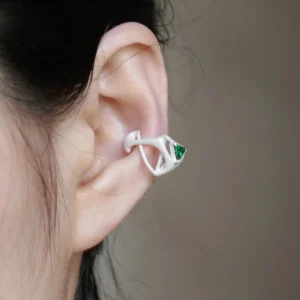 Close-up of ear wearing Dreamscape Garden S925 Silver Ear Cuff with green triangular gemstone and sculptural silver design; a modern Silver Ear Cuff blending botanical inspiration and geometric elegance.