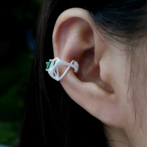 Close-up of ear wearing Dreamscape Garden S925 Silver Ear Cuff with green triangular gemstone and sculptural silver design; a botanical-inspired Silver Ear Cuff blending geometric elegance and artistic craftsmanship.
