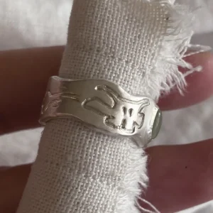 Side view of Lazesoul green apple 999 silver prehnite ring showing carved ghost motif on linen roll
