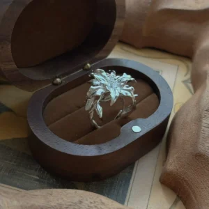 Handmade S925 Sterling Silver Lily Ring with intricate floral design, placed in an open wooden ring box; detailed petals and leaves evoke natural elegance, highlighting the craftsmanship of this artistic Silver Ring inspired by the lily flower.