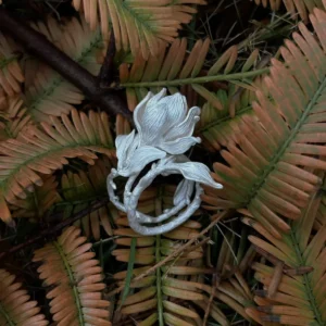 Handmade S925 Sterling Silver Magnolia Ring with sculpted petals and stem details, placed on dried fern leaves; a nature-inspired Silver Ring celebrating Magnolia Jewelry craftsmanship and botanical elegance.