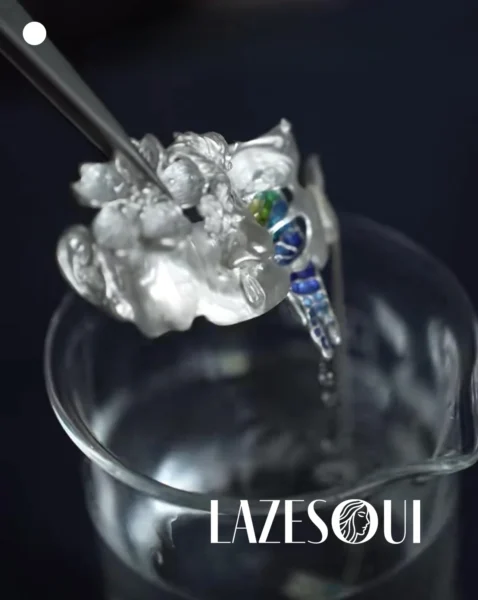 Blogs 4 Silver jewelry held with tweezers above a glass bowl during the cleaning process